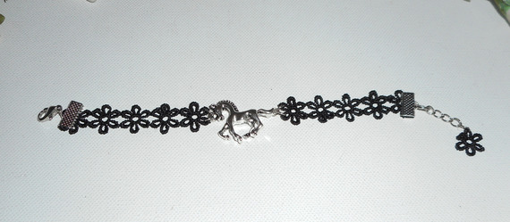 Bracciale originale con cavallo in metallo argentato su pizzo nero