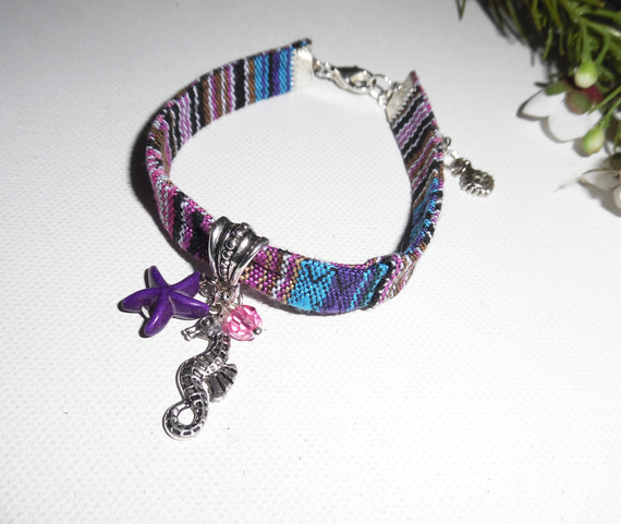 Bracciale in tessuto colorato con nappe a forma di cavalluccio marino e stella marina viola