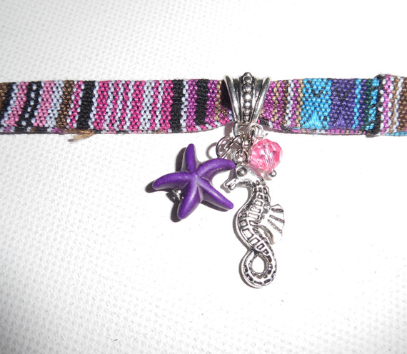 Bracciale in tessuto colorato con nappe a forma di cavalluccio marino e stella marina viola