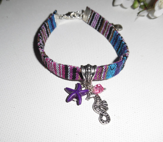 Bracciale in tessuto colorato con nappe a forma di cavalluccio marino e stella marina viola