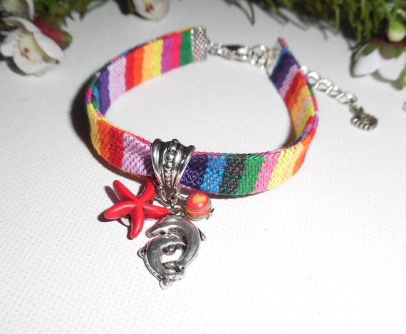 Bracciale in tessuto colorato con delfino e nappe rosse a forma di stella marina